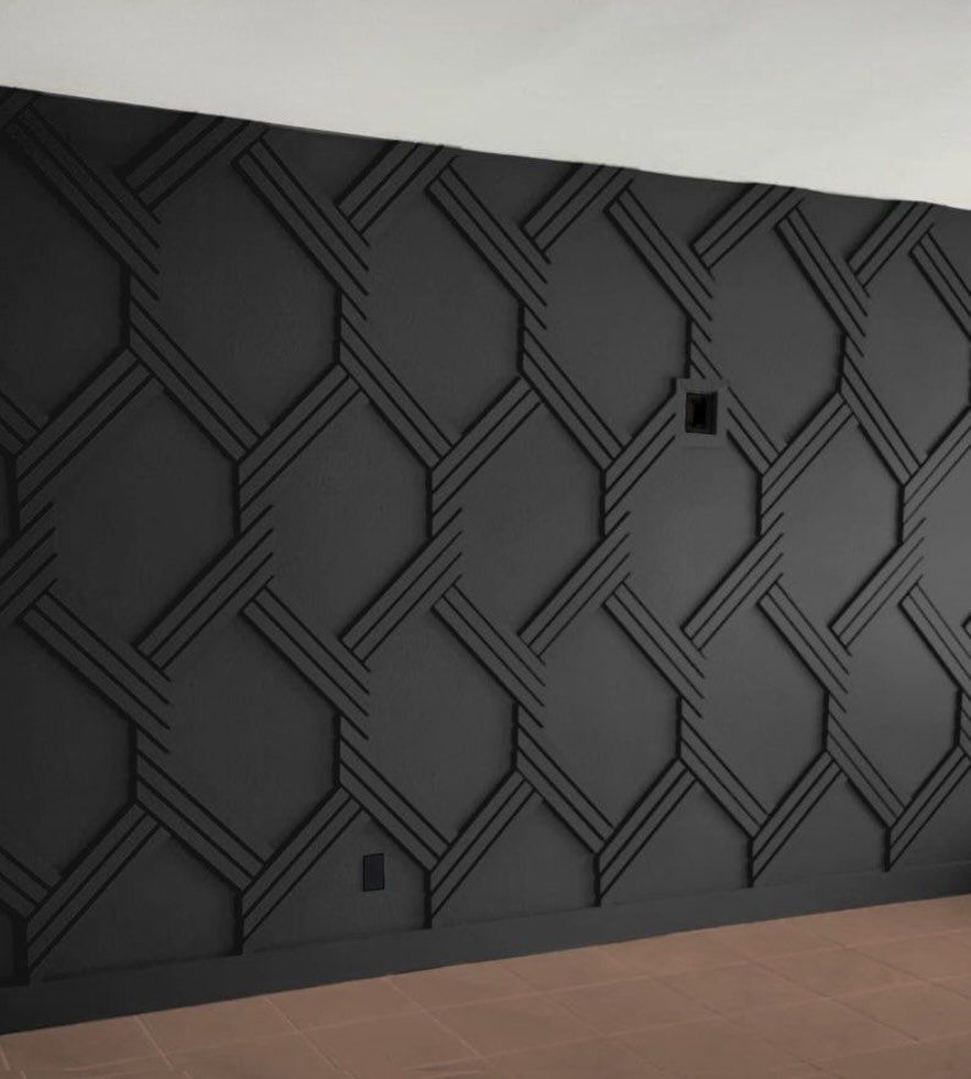 Charcoal grey wall with a raised geometric pattern of interlocking lines and hexagonal shapes.