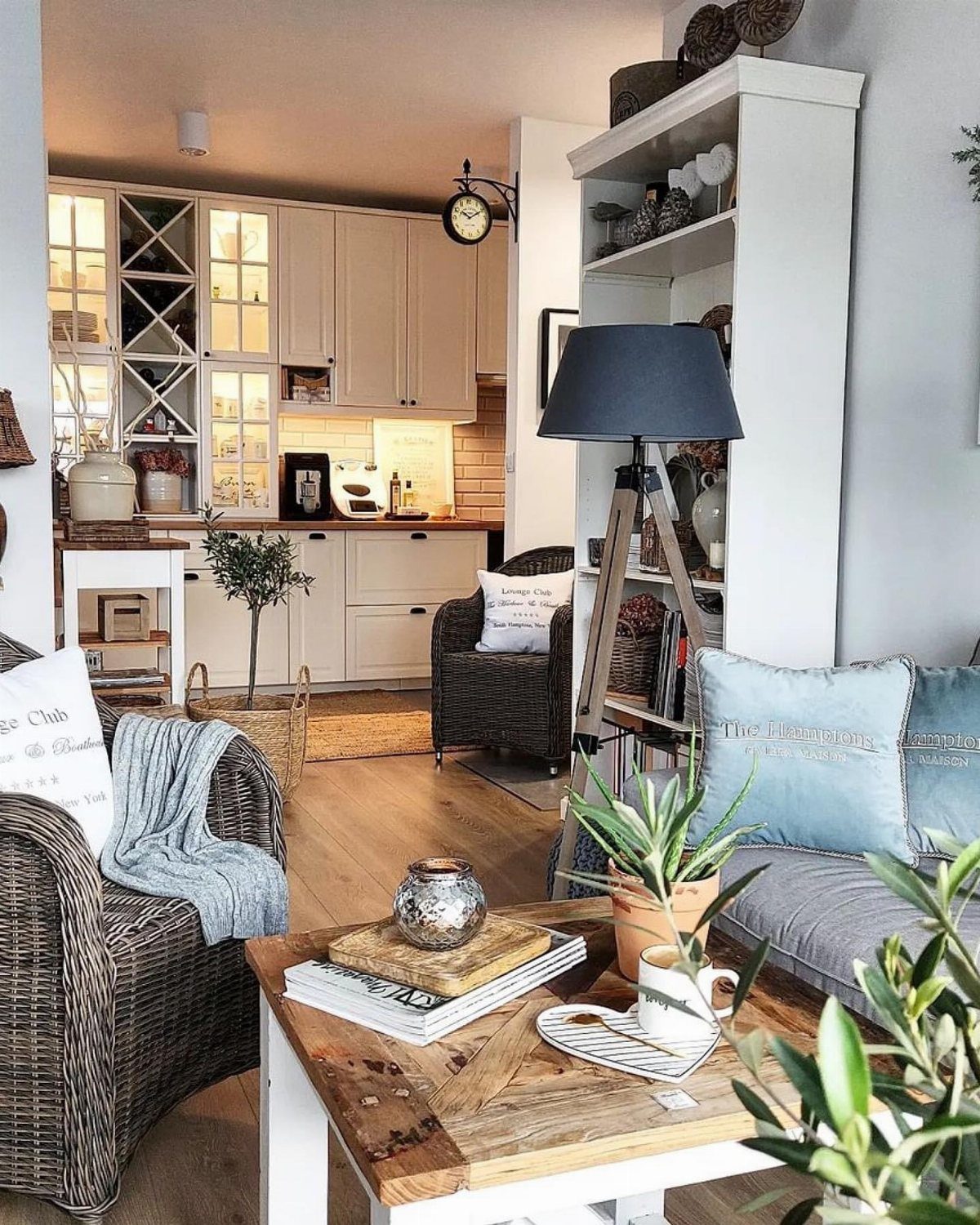Wicker armchairs and a grey sofa arranged around a rustic wooden coffee table.