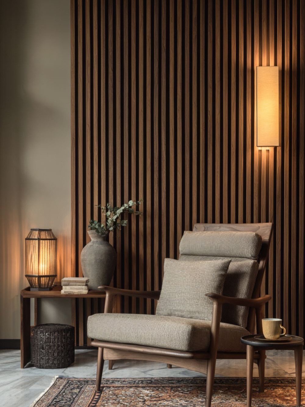 Vertical dark wood slat wall paneling behind a mid-century modern armchair and side table.