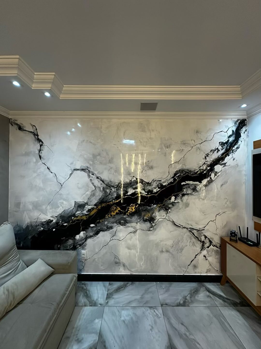 Large marble-effect wall panels with black and gold veining in a modern living room setting.